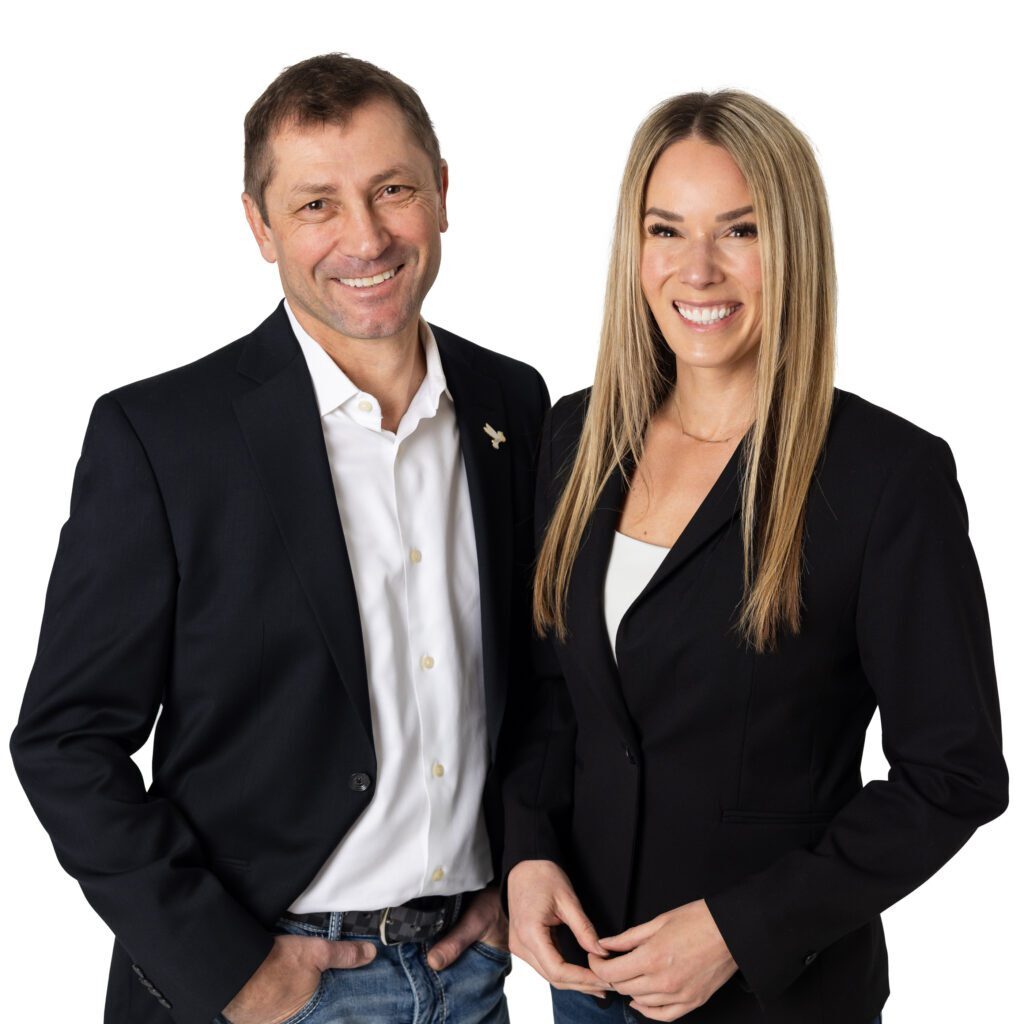 A man and woman dressed in business attire smiling at the camera.